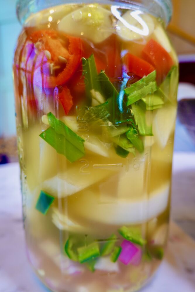 quart canning jar filled with jalapenos, onion, garlic, in apple cider vinegar