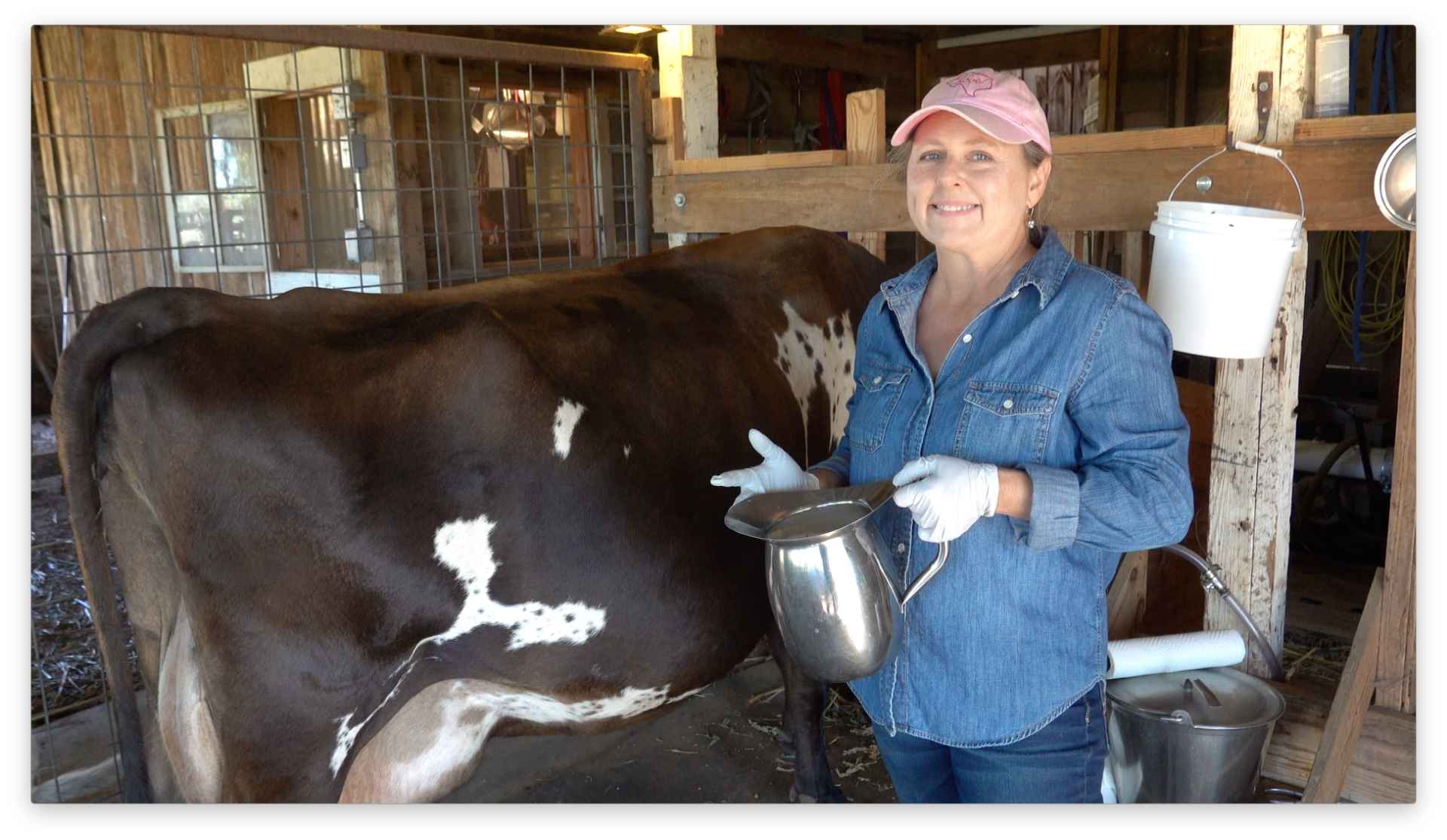 women holding a pitcher of raw milk with jersey cow