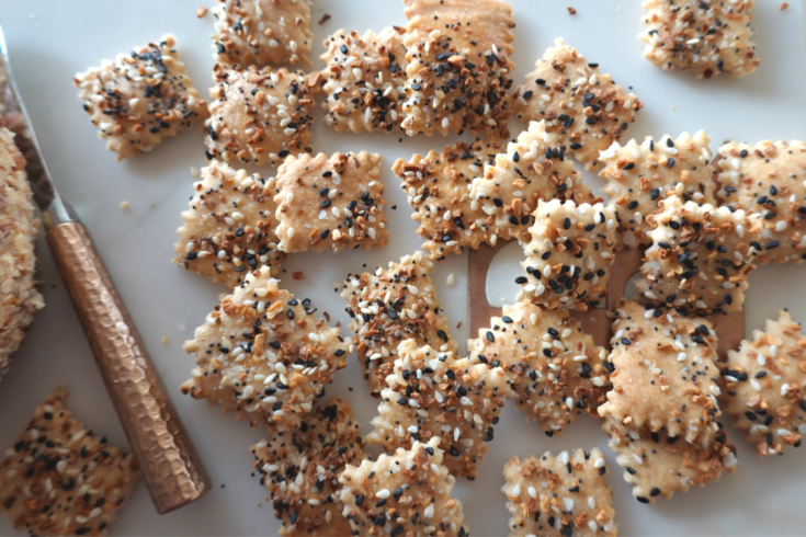 sourdough everything crackers are displayed with a cheese ball