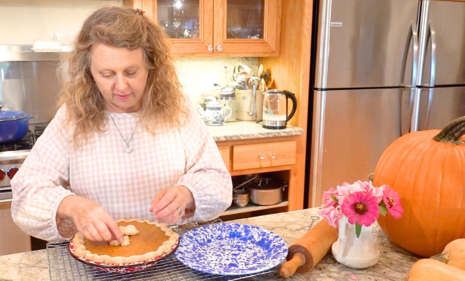 adding decoration to the top of a pumpkin pie